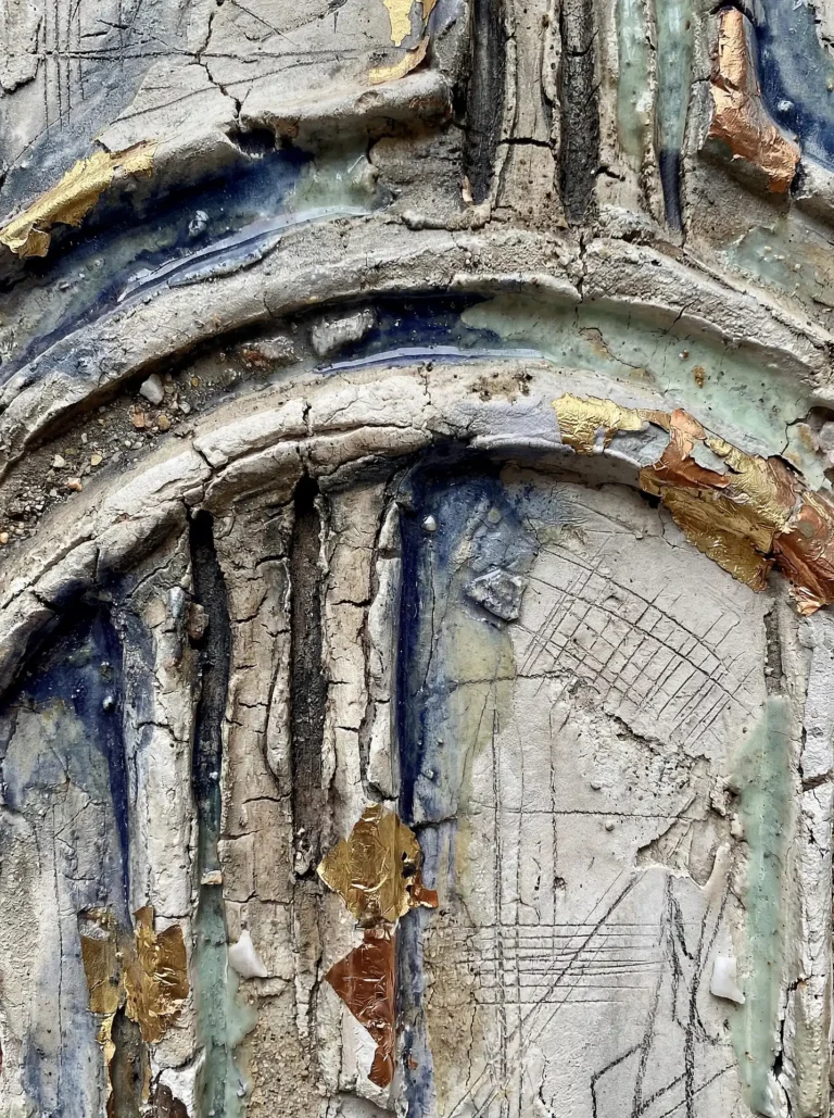 Earthy and ancient in its atmosphere, this textured relief features deep architectural fissures and delicate cross-hatched etchings. The neutral plaster surface is accented by brilliant gold leaf fragments and flowing crystalline blue glazes that create a sense of tactile history. Artwork by Constantine Cheshire