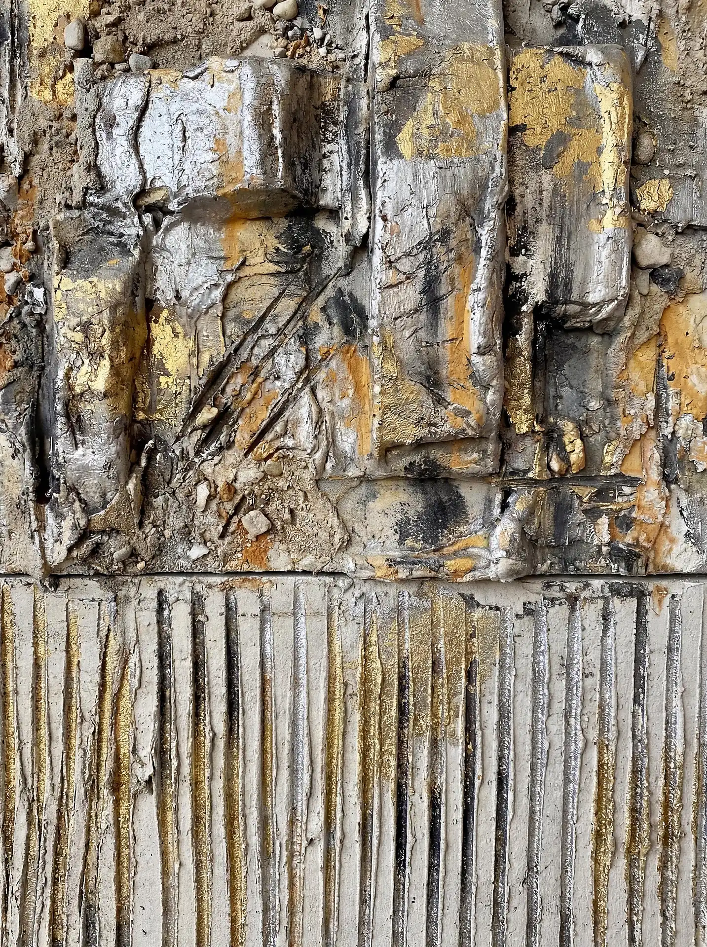 Industrial and weathered atmosphere defines this mixed media piece featuring heavy gold and silver leaf over vertical concrete ridges. This tactile wall sculpture blends raw building materials with luxurious metallic finishes to create a contemporary focal point. Artwork by Constantine Cheshire