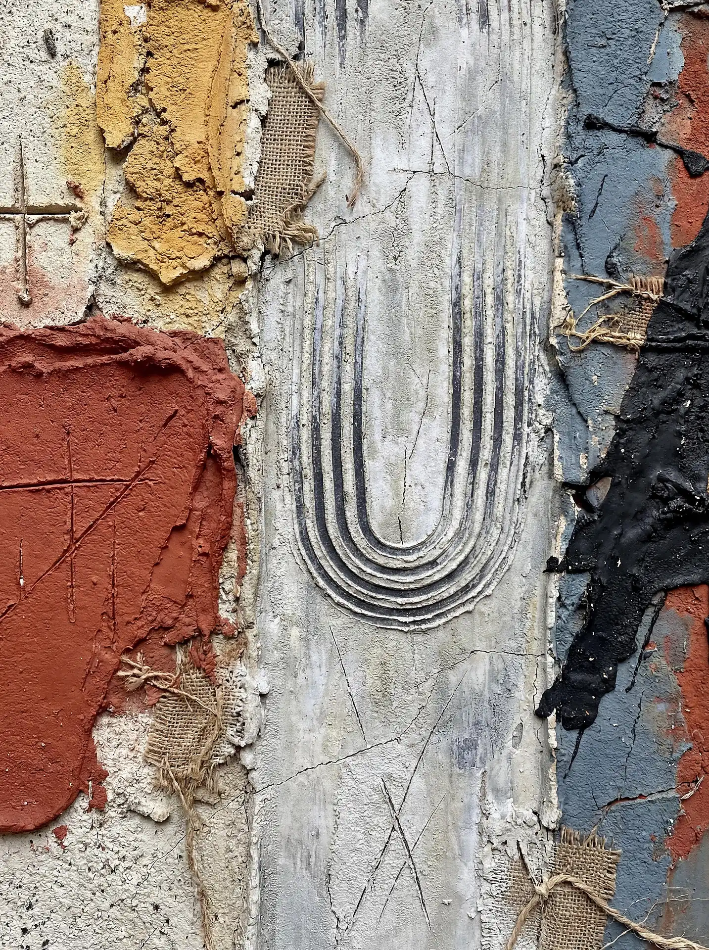 Gritty and industrial, this textured composition features raw burlap remnants embedded in cracked white plaster and bold red impasto paint. The tactile surface uses deep carved grooves and layered earth tones to create a sense of weathered urban archaeology. Artwork by Constantine Cheshire