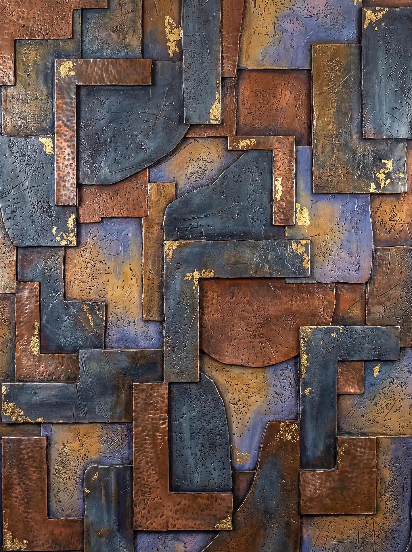 Hammered copper and weathered steel plates create a rugged, three-dimensional collage with shimmering gold leaf highlights. This abstract wall sculpture combines geometric shapes and rich earth tones to evoke a sense of aged industrial craftsmanship and modern elegance. Artwork by Constantine Cheshire