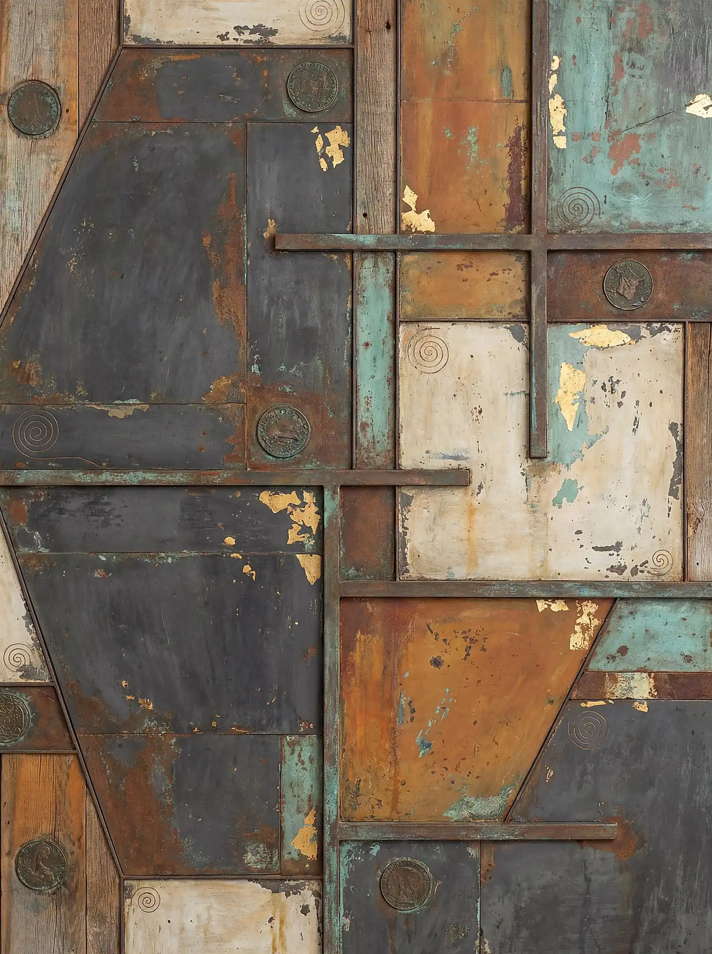 Earthy rust and verdigris tones define this mixed media collage featuring weathered metal, aged wood, and shimmering gold leaf accents. This abstract composition incorporates vintage medallions and delicate spiral engravings to create a rich, multi-layered industrial texture. Artwork by Constantine Cheshire