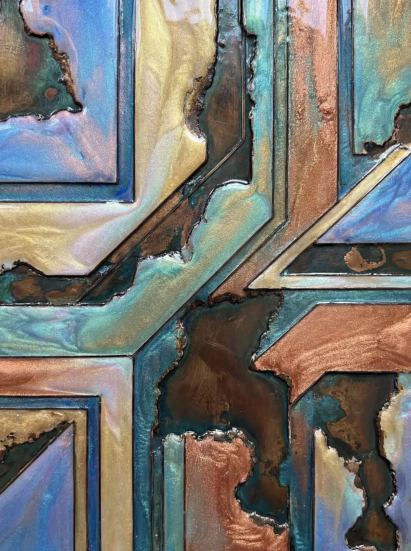 Layered geometric compartments create a complex grid filled with shimmering pearlescent teal and copper resin. This modern mixed media piece features a striking juxtaposition between clean linear borders and raw, organic eroded textures that catch the light with an iridescent glow. Artwork by Constantine Cheshire
