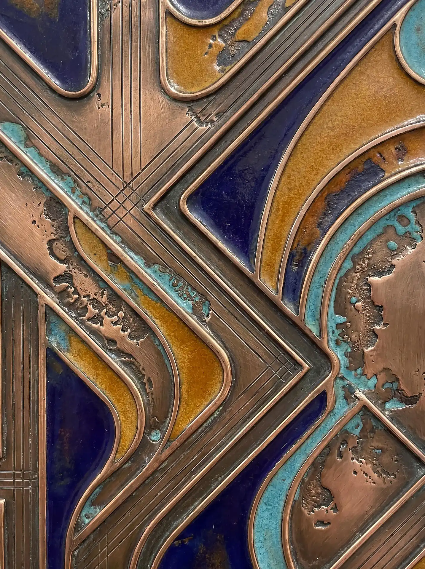 Deep cobalt and earthy copper tones illuminate this intricate abstract metal relief piece. The artwork features a sophisticated blend of polished metal textures, weathered turquoise oxidation, and glossy enamel inlays arranged in a geometric, Art Deco-inspired composition. Artwork by Constantine Cheshire