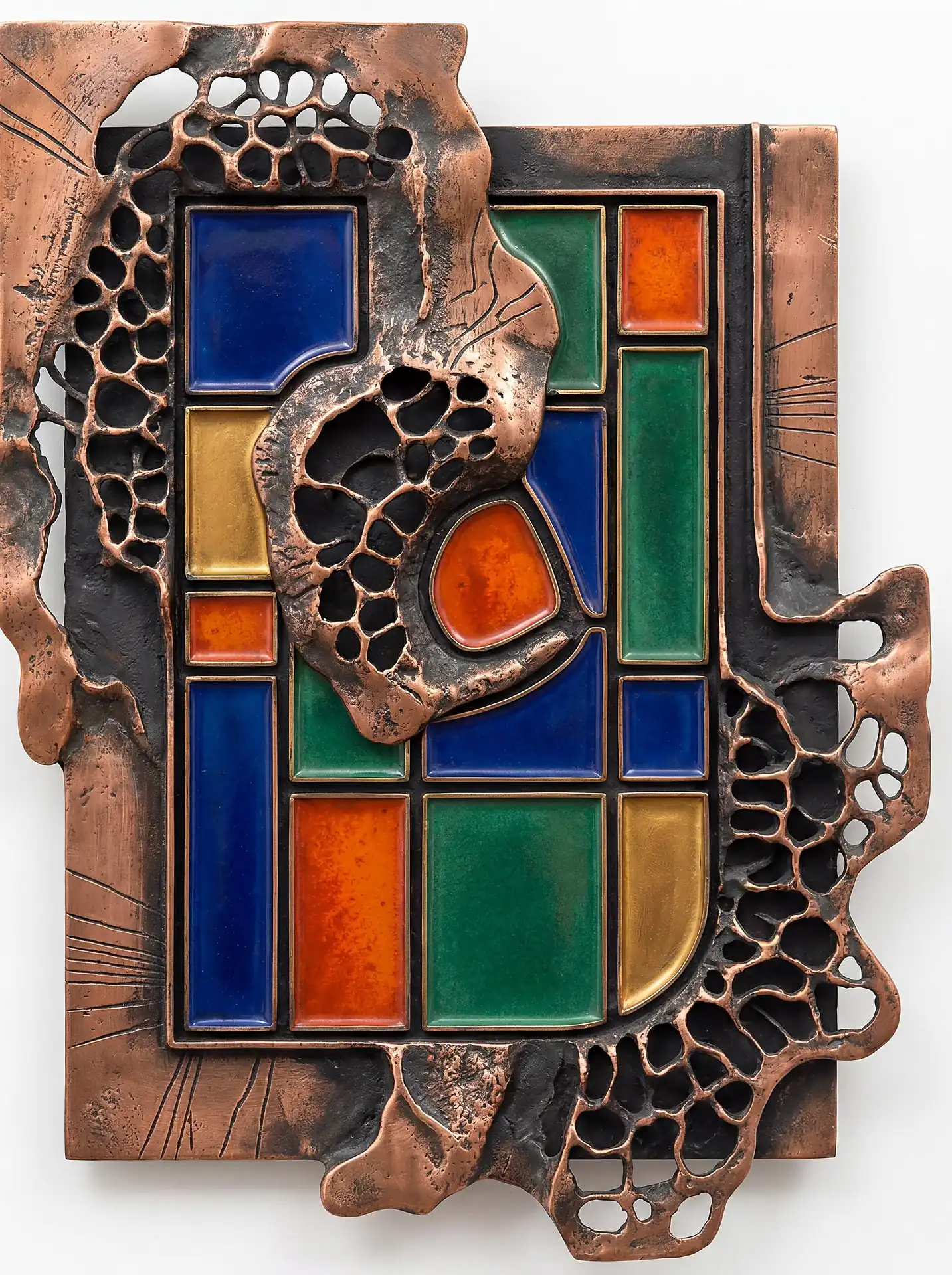 Hammered copper and porous bronze textures frame an organized grid of vibrant blue, orange, and green enamel cells. This abstract relief sculpture blends organic, molten metal edges with structured geometric shapes to create a sophisticated brutalist aesthetic. Artwork by Constantine Cheshire