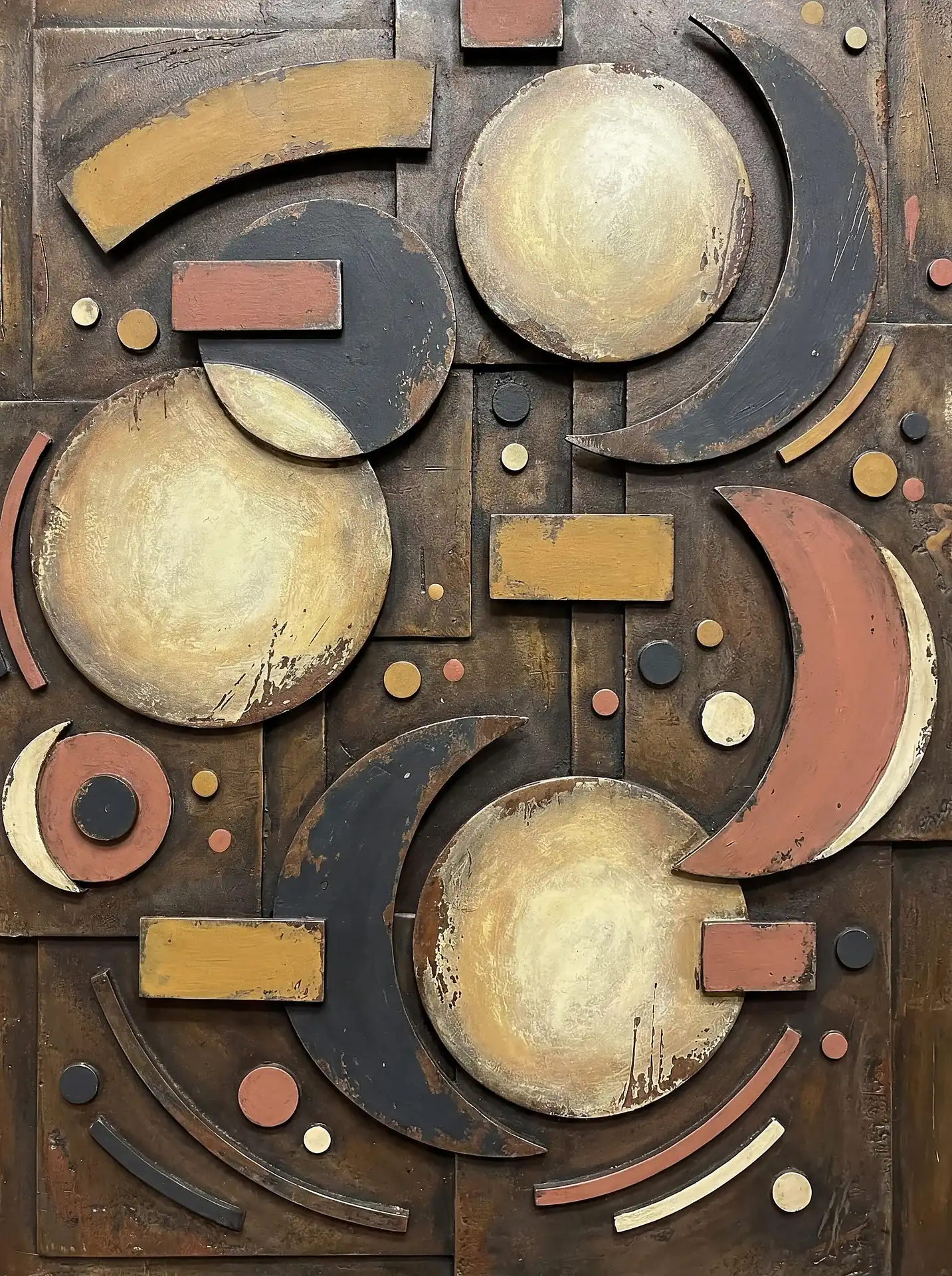 Orbiting through space, these weathered metal crescents and circles create a textured geometric relief sculpture. This mixed media artwork utilizes a rich palette of bronze and gold with a distressed finish to suggest a cosmic or steampunk aesthetic. Artwork by Constantine Cheshire